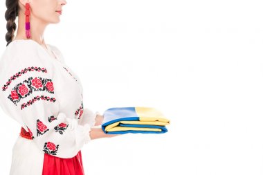 cropped view of young woman in national Ukrainian costume holding flag isolated on white clipart