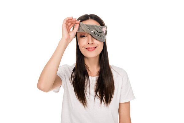 smiling brunette young woman in cat sleeping eye mask isolated on white