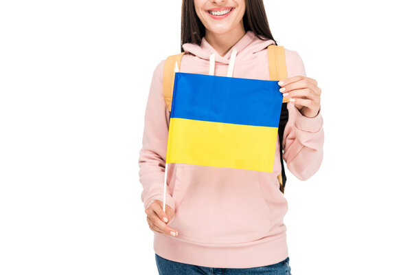 cropped view of smiling student with backpack holding Ukrainian flag isolated on white