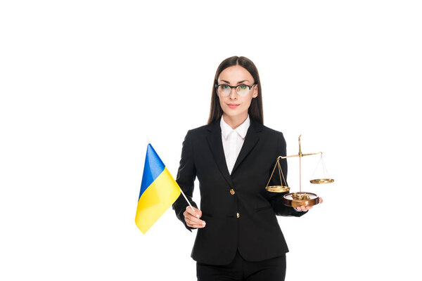 адвокат в черном костюме с украинским флагом и весами на правосудии изолирован по белому
