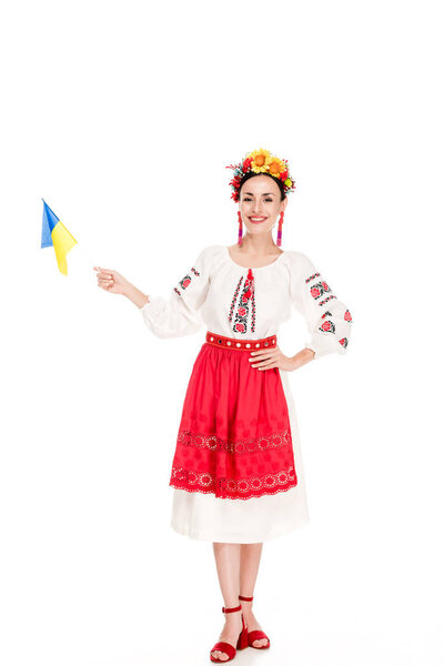 brunette young woman in national Ukrainian costume holding flag of Ukraine isolated on white