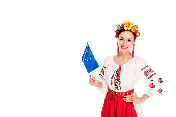 happy brunette young woman in national Ukrainian costume holding European flag isolated on white