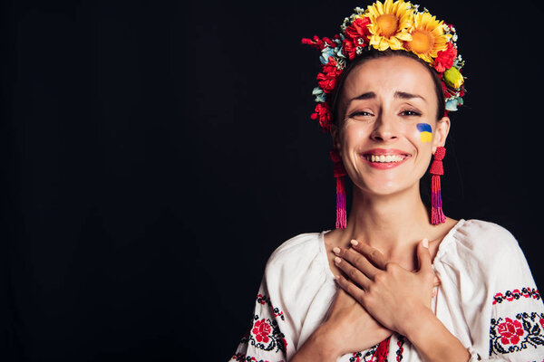 happy brunette young woman in national Ukrainian costume isolated on black