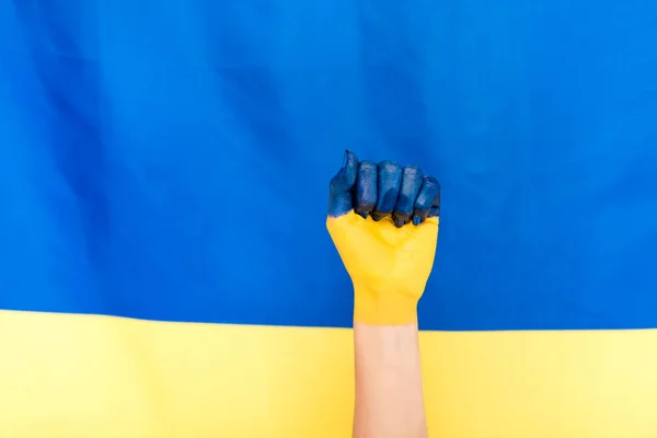在乌克兰国旗背景上绘制的手的裁剪视图 — 图库照片