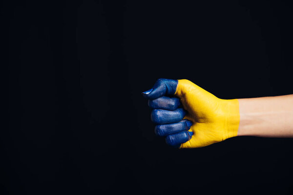 cropped view of hand painted in Ukrainian flag colors isolated on black