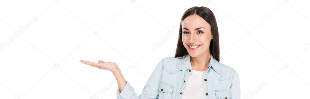 happy brunette woman pointing with hand isolated on white, panoramic shot