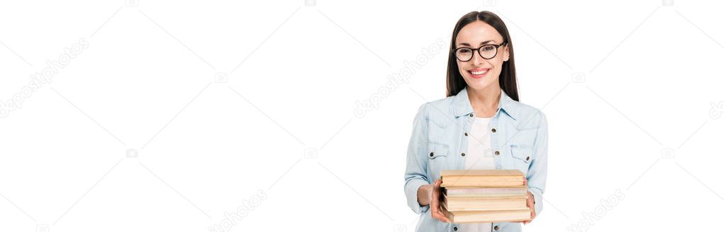 happy brunette girl in glasses in denim jacket holding books isolated on white, panoramic shot