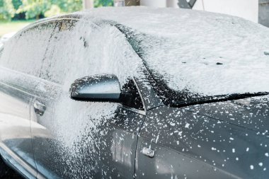 modern grey car with white foam in car wash  clipart
