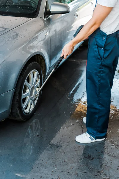 外の灰色の近代的な自動車の近くに立っている男のトリミングされたビュー — ストック写真