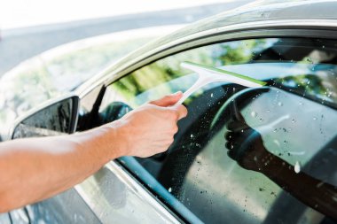 araba penceresi temizlerken squeegee tutan araba temizleyici kırpılmış görünümü 