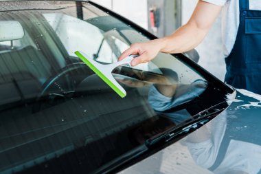 araba penceresi yıkarken squeegee tutan araba temizleyici kırpılmış görünümü 