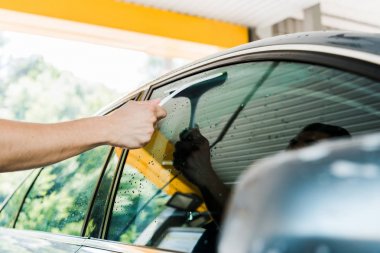 squeegee tutan ve araba penceresi yıkama adam seçici odak 