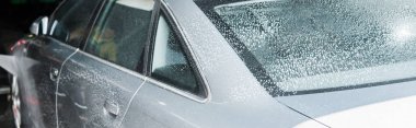 panoramic shot of grey auto with white foam in car wash  clipart