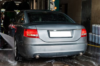 oto yıkama hizmetinde gri araba üzerinde su basıncı 