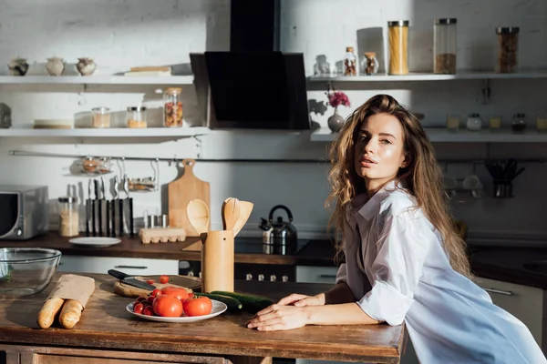 Atraente Jovem Mulher Perto Mesa Cozinha Olhando Para Câmera — Fotografia de Stock