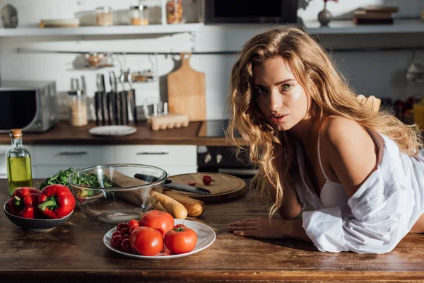 Sexy Joven Mujer Acostada Mesa Mirando Cámara Cocina —  Fotos de Stock
