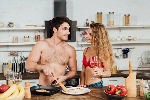 Sexy Girl Holding Wine Glass While Shirtless Boyfriend Cooking Kitchen — Stock Photo, Image