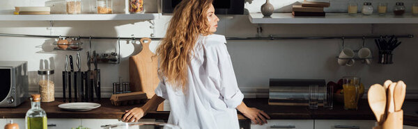 panoramic shot of girl in white shirt standing in kitchen