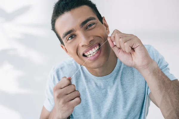 Молодой Человек Пользующийся Зубной Нитью Смотрящий Камеру — стоковое фото