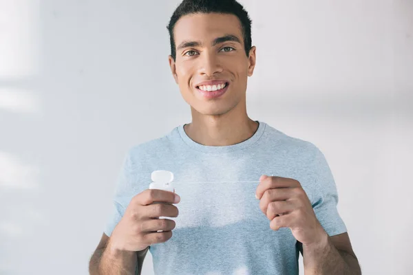 Guapo Joven Sosteniendo Hilo Dental Mientras Mirando Cámara —  Fotos de Stock