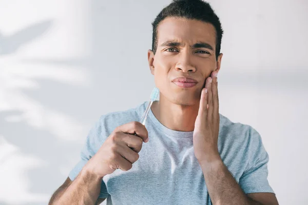 Bonito Jovem Homem Segurando Escova Dentes Enquanto Tendo Dor Dente — Fotografia de Stock