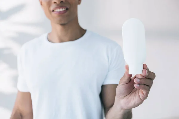 Vista Cortada Homem Segurando Garrafa Branca Com Creme Facial — Fotografia de Stock