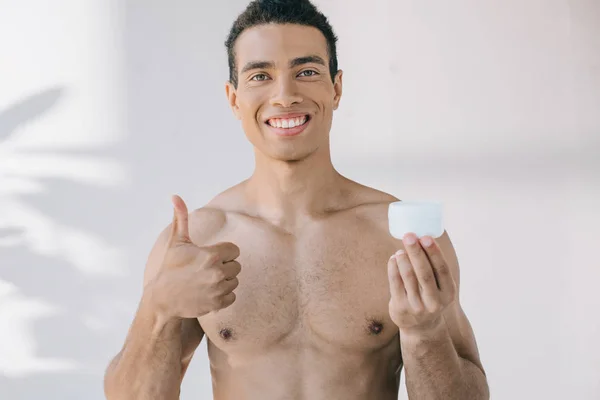 Pohledný Muž Který Drží Kosmetický Krém Ukazoval Palec Nahoru Usmívá — Stock fotografie