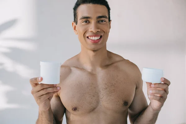 Shirtless Young Man Holding Two Containers Cosmetic Cream Smiling Looking — Stock Photo, Image