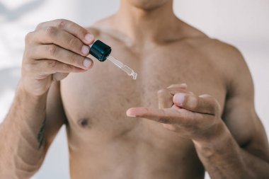 karışık ırk adam seçici odağı parmak pipet gelen serum bırakarak 