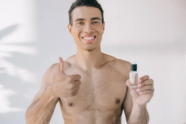 Mixed Race Man Holding Bottle Serum Showing Thumb While Looking — Stock Photo, Image