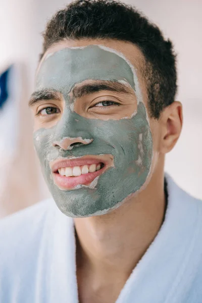 Güzel Adam Bornoz Yüz Üzerinde Kil Maskesi Ile Portre Çekimi — Stok fotoğraf