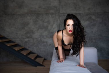 kanepe üzerinde siyah iç çamaşırı ayakta seksi kız ve kamera bakıyor