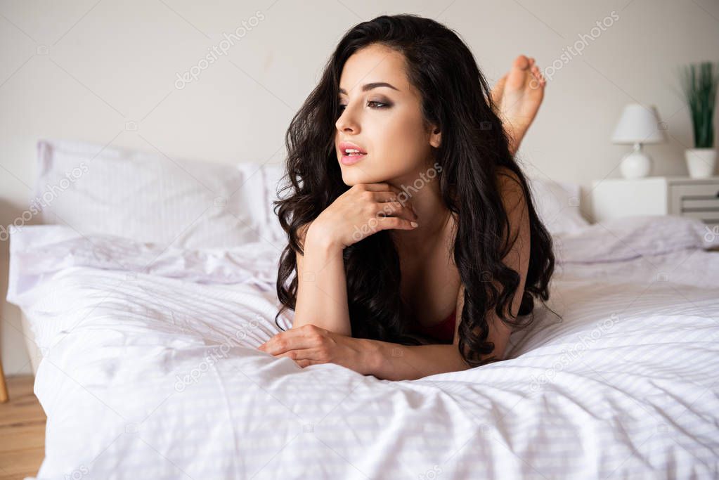 beautiful girl lying on bed and looking away