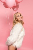 glücklich schöne sexy blonde Frau in weißer Kunstpelzjacke mit Luftballons auf rosa
