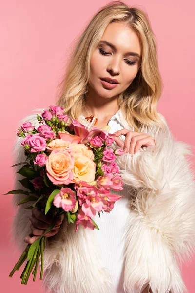 재킷과 수트에 아름다운 금발의 여자는 핑크에 꽃을보고 — 스톡 사진