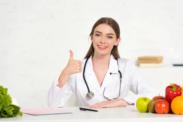 Vista Frontal Nutricionista Sorridente Casaco Branco Com Estetoscópio Mostrando Polegar — Fotografia de Stock