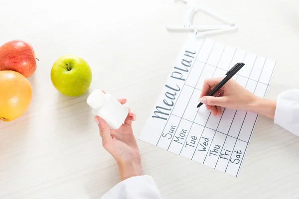 Bijgesneden Weergave Van Diëtiste Het Houden Van Pillen Schrijven Maaltijdplan — Stockfoto