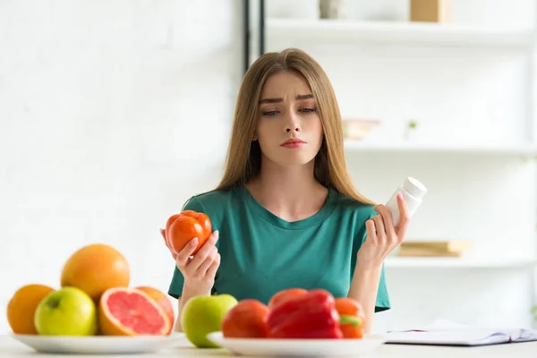 Sad Woman Sitting Table Fruits Vegetables Holding Pills Tomato — Stock Photo, Image