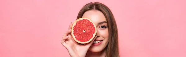 Panoramatický Záběr Usmívající Atraktivní Dívky Odřízovaným Grapefruitu Izolovaným Růžovém — Stock fotografie