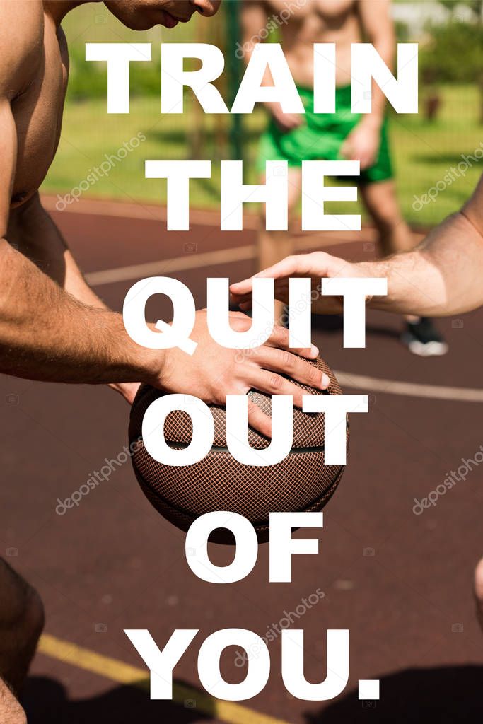 train the quit out of you lettering on cropped view of sportsmen playing basketball at basketball court