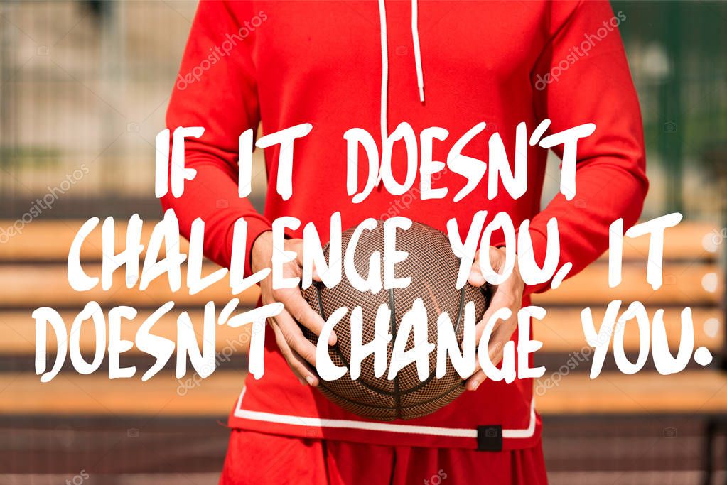 if it doesnt challenge you it doesnt change you lettering on partial view of basketball player holding ball