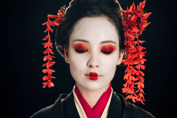 portrait of beautiful geisha with flowers in hair isolated on black