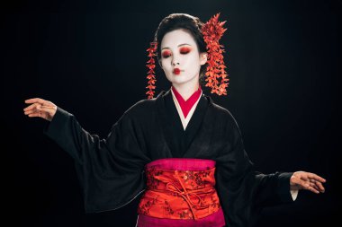 siyah ve kırmızı kimono güzel geyşa ve saç çiçekleri aşağı bakıyor ve siyah izole gesturing