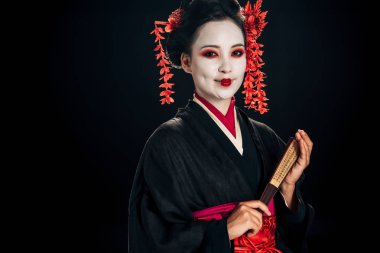 siyah siyah izole geleneksel asya el fan tutan saç kırmızı çiçekler ile siyah kimono mutlu geyşa