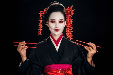 siyah kimono mutlu güzel geyşa saç tutarak çubukları siyah izole kırmızı çiçekler ile