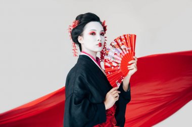 beyaz izole arka plan üzerinde el fanı ve kırmızı bez ile siyah kimono güzel geyşa
