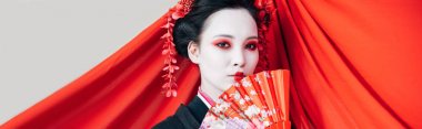 beyaz, panoramik çekim izole arka plan üzerinde el fanı ve kırmızı bez ile siyah kimono güzel geyşa