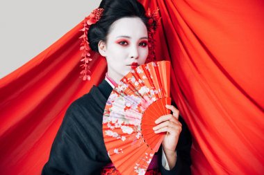 beyaz izole arka plan üzerinde el fanı ve kırmızı bez ile siyah kimono güzel geyşa