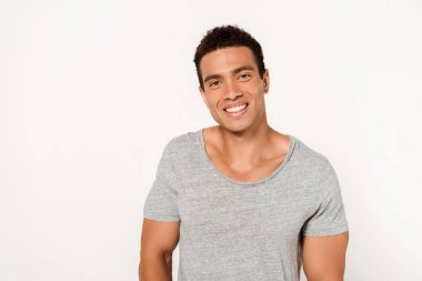  happy mixed race man smiling while looking at camera on white  clipart