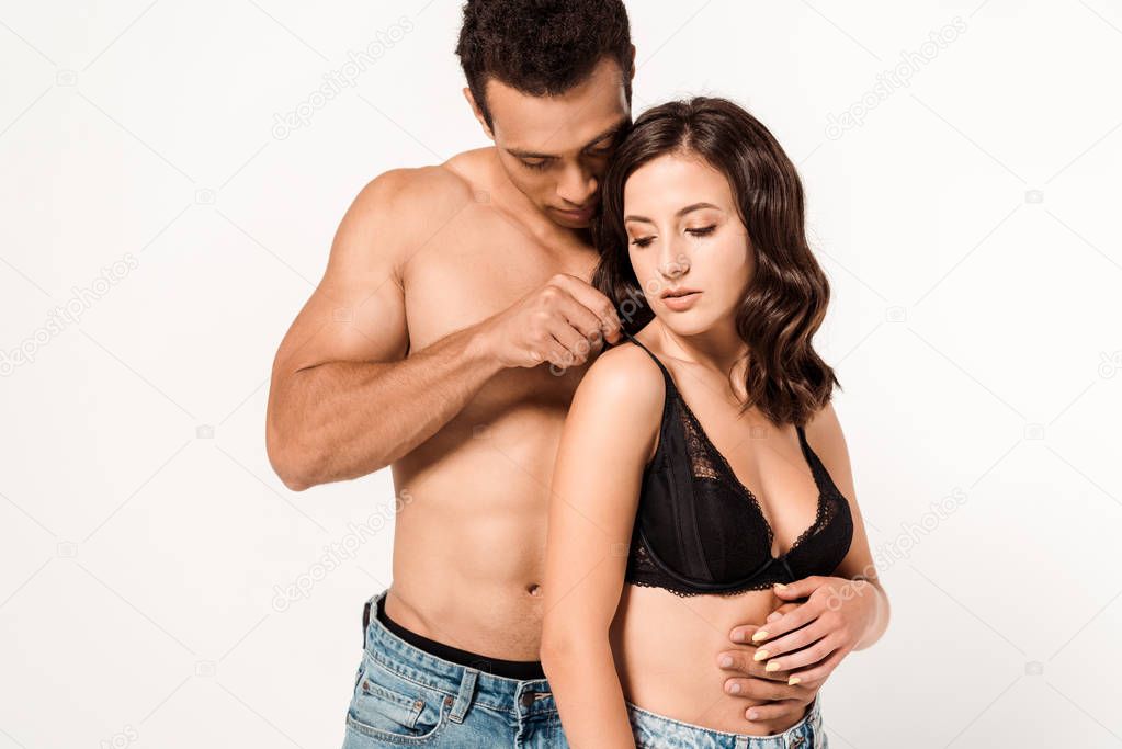 sexy mixed race man touching black bra of attractive woman isolated on white 
